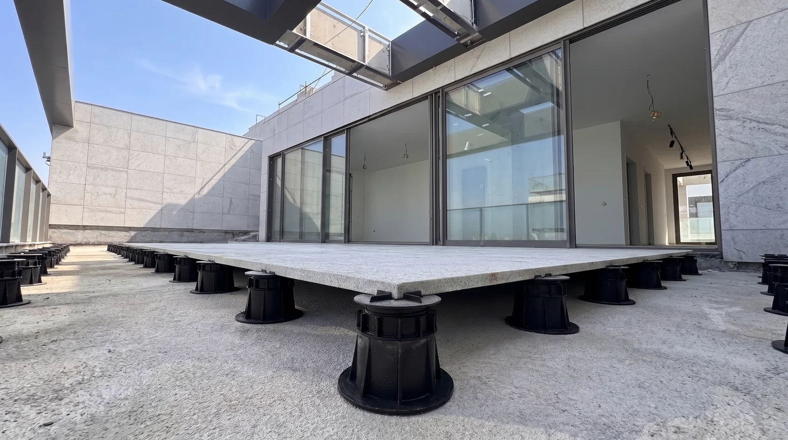 Piso elevado em granito flameado com pedestais aparentes